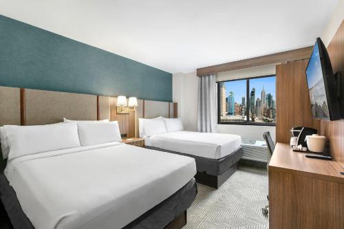 纽约切尔西曼哈顿第六大道假日酒店 的酒店客房设有两张床和窗户。