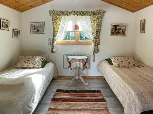 格里斯勒港Holiday home GRISSLEHAMN XV的一间卧室设有两张床、一个窗口和一张桌子