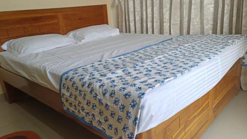 拉特纳吉里Great Hornbill Homestay, Ratnagiri的床上有蓝色和白色的毯子