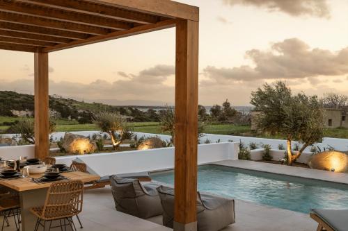 纳克索斯岛卡斯特拉基P square Luxury villas Naxos的一个带桌椅的户外庭院和一个游泳池