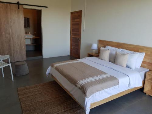 格兰贝伊Villas Rocher - Standard Suite 3A的卧室配有一张带白色床单和枕头的大床。