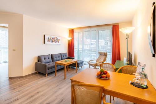 赛巴特班森Aparthotel Tropenhaus Bansin的客厅配有沙发和桌子
