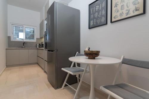 雅典LuxLoom Athens next to Hilton的厨房配有白色的桌子和冰箱。