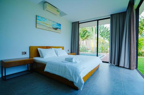 富国Kiwuki Beachfront Villa的一间卧室设有一张床和一个大窗户