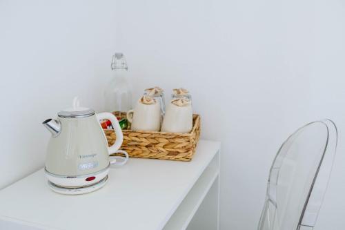 塞勒里古ABC affittacamere的一间白色的厨房,在柜台上配有两个茶壶