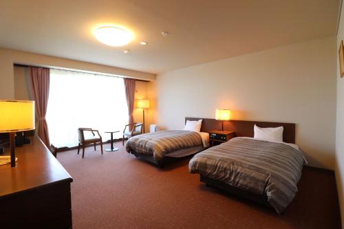 带广格兰德瑞奥十胜幕别温泉酒店的酒店客房设有两张床和窗户。