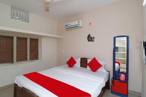 普里Goroomgo Padoshi Near Sea Beach Puri - Spacious Room 100 Meters From Sea Beach的一间卧室配有一张带红色枕头的床