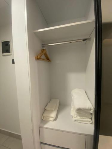 阿克拉Kass Towers, Studio Apartment的架子上带两条白色毛巾的衣柜