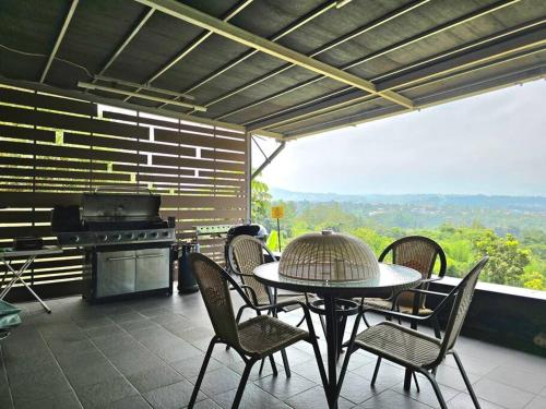 Gadok 1Villa Montaview Puncak (Mountain View Cottage)的一个带桌椅和烧烤架的庭院