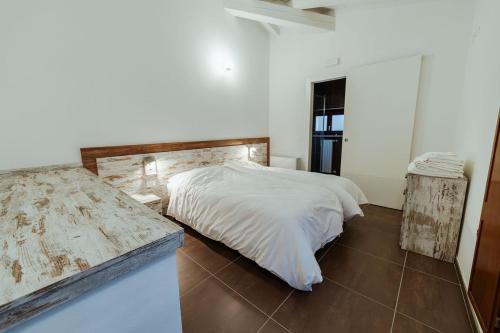 雷扎托Hotel Alla Sosta的白色卧室配有床和镜子
