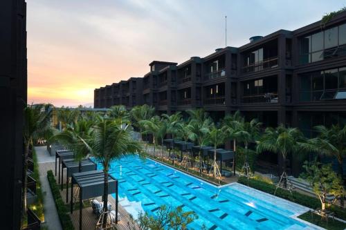 拉威海滩Luxury King Bed Apartment with Pool View and Sauna的一座大型酒店,在一座建筑前设有一个游泳池