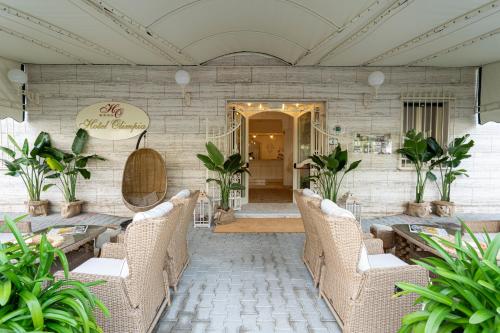 马尔米堡奥林匹亚酒店的一间设有藤椅和桌子的餐厅,种植了植物