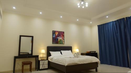 迪拜PRIVATE ROOM WITH WASHROOM AND BALCONY的一间卧室配有床、镜子和蓝色窗帘