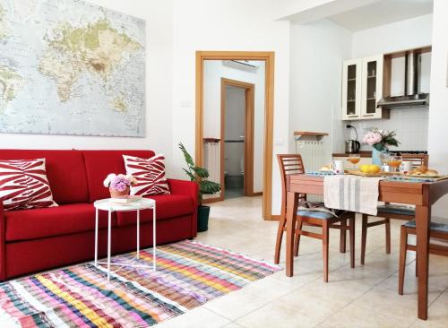 托尔托雷托Holihome_Casa di Stefano 50m dal mare的客厅配有红色的沙发和桌子