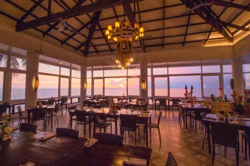 马比尼鹰角海滩潜水度假酒店的一间带桌椅和吊灯的餐厅