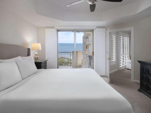 默特尔比奇Royale Palms Condominiums的卧室配有白色床,享有海景