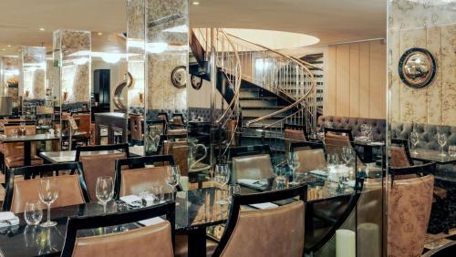 伦敦格林威治酒店的一间带桌椅和楼梯的用餐室
