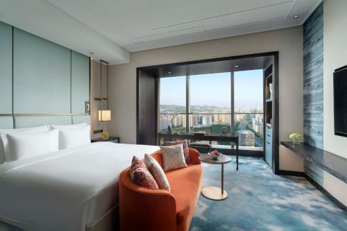 济南济南凯宾斯基酒店的一间带大床的卧室和一间客厅
