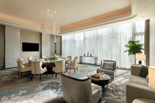 济南济南凯宾斯基酒店的一间带桌椅的客厅和一间用餐室