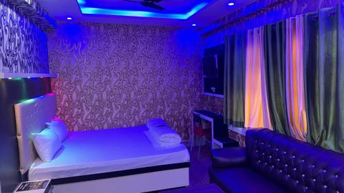 巴特那Relax Zone的紫色的客房配有一张床和一张沙发