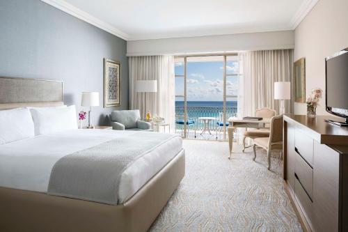 坎昆Kempinski Hotel Cancun的酒店客房配有一张床和一张书桌及一台电视