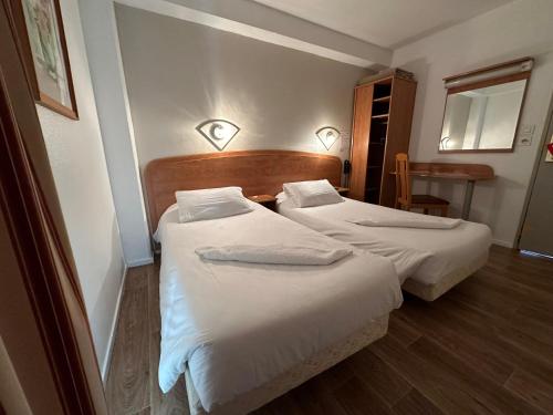 桑斯HAVANA Hôtel的配有白色床单的酒店客房内的两张床