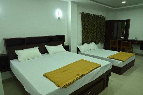 玛莱尤尔GR INN的一间卧室配有两张带黄床单的床