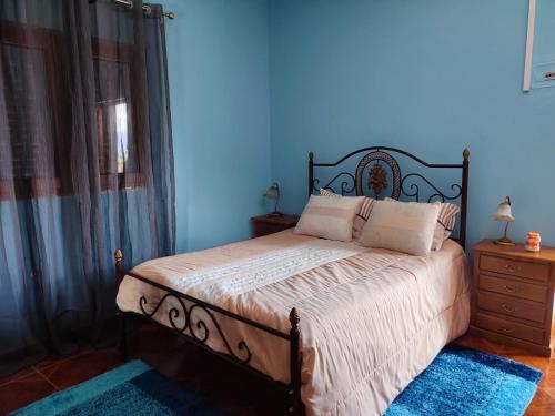 阿利若Vivenda Casa da Fraga的一间卧室配有一张蓝色墙壁的床