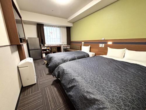 仓敷仓敷市1-2-3酒店的酒店客房设有两张床和电视。