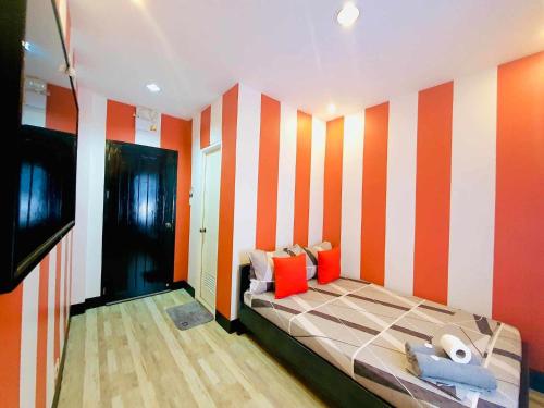 科隆DK's Inn的一间卧室配有一张橙色和白色条纹的床