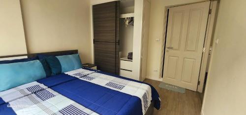 清迈An Na Park Hotel Room - Chiang Mai的卧室配有蓝色和白色的床和衣柜。