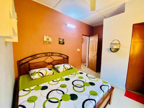瓦加杜古Cool meuble的一间卧室配有一张带绿色和白色棉被的床