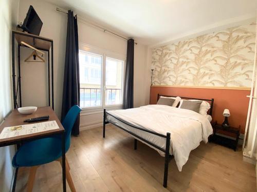 勒阿弗尔L'Escale Appartements et Suites en bord de Mer的一间卧室配有一张床、一张桌子和一张书桌
