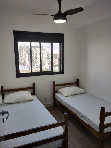 圣保罗Piscine Resort Brás的带窗户的客房内的两张床