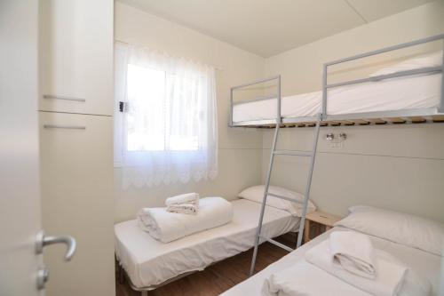 莱德罗Mobilhome Camping Azzurro的客房设有两张双层床和镜子
