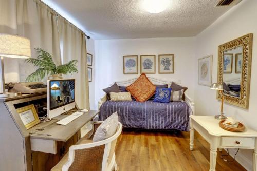 圣徒皮特海滩Blue Beach Cottage的一间卧室配有一张床和一张带电脑的书桌