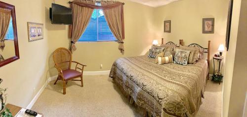 PittsfieldMonroe Street Suites的卧室配有床、椅子和窗户。