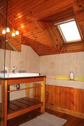 FaverollesL'autre Monde的带浴缸、水槽和窗户的浴室