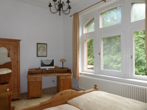 汉诺威托斯卡别墅酒店的卧室配有一张床、一张书桌和窗户。