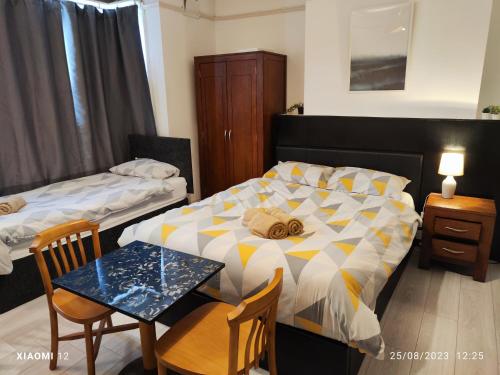 莱斯特St Lucia Leicester的卧室配有一张床和一张桌子及椅子