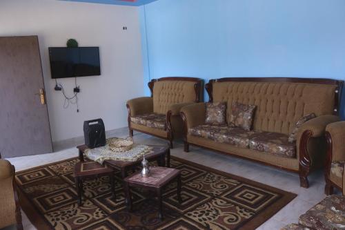 Aş ŞāfīWalaa Chalet的客厅配有两张沙发和一台电视机