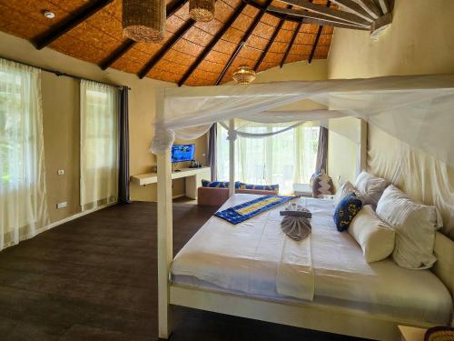 科洛里Balafon Beach Resort的一间卧室,卧室内配有一张天蓬床