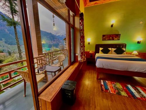 马拉里4 Bedroom Luxury Bungalow in Manali with Beautiful Scenic Mountain & Orchard View的一间卧室设有一张床和一个美景阳台