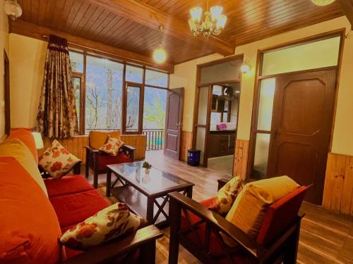 马拉里4 Bedroom Luxury Bungalow in Manali with Beautiful Scenic Mountain & Orchard View的客厅配有沙发和桌子