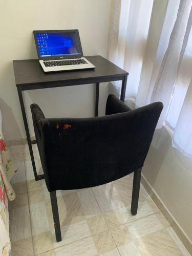 贝伦Quarto confortável perto de tudo 03的一张桌子,椅子上配有一台笔记本电脑