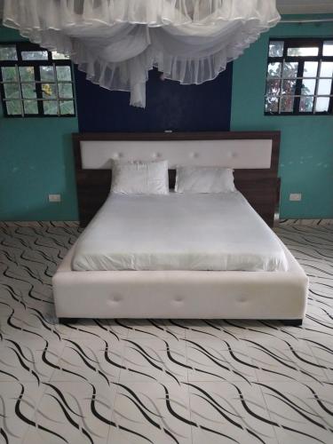 基苏木Radisson Villa的卧室内的白色床和蓝色的墙壁