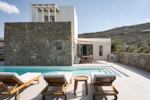 米克诺斯城Retreat Hill Luxury Villas Mykonos的一座带游泳池、椅子和房屋的别墅