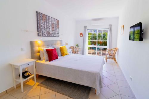 拉戈斯Casas Novas Guesthouse - Adults Only的一间卧室配有一张床、一张桌子和一个窗户。