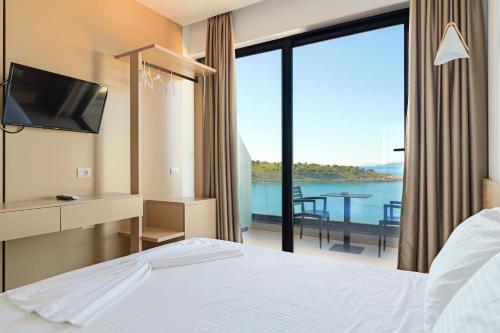 萨兰达Villa Xhefri 2的酒店客房配有一张床,享有水景