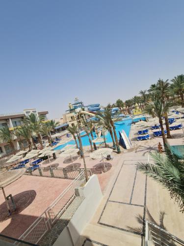 赫尔格达ميراج باي (شاليه)的一个带椅子和棕榈树的游泳池的度假酒店